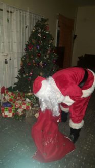 IMAGE 5- Fontana Santa placing Gifts donated by customers under the tree at the St. Anthony's and St Mary's Childrens Home